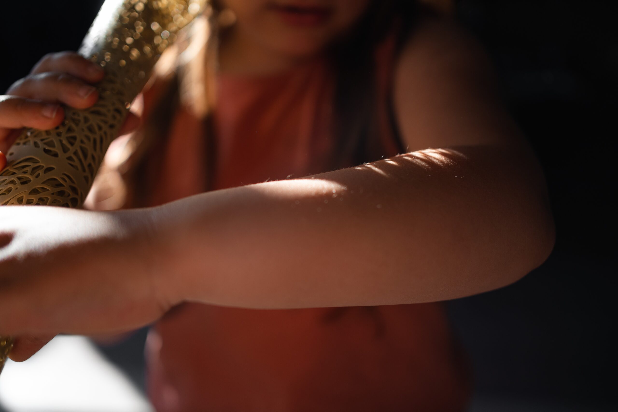 5 years old girl in morning sunlight at hime looking at the sun on her hand