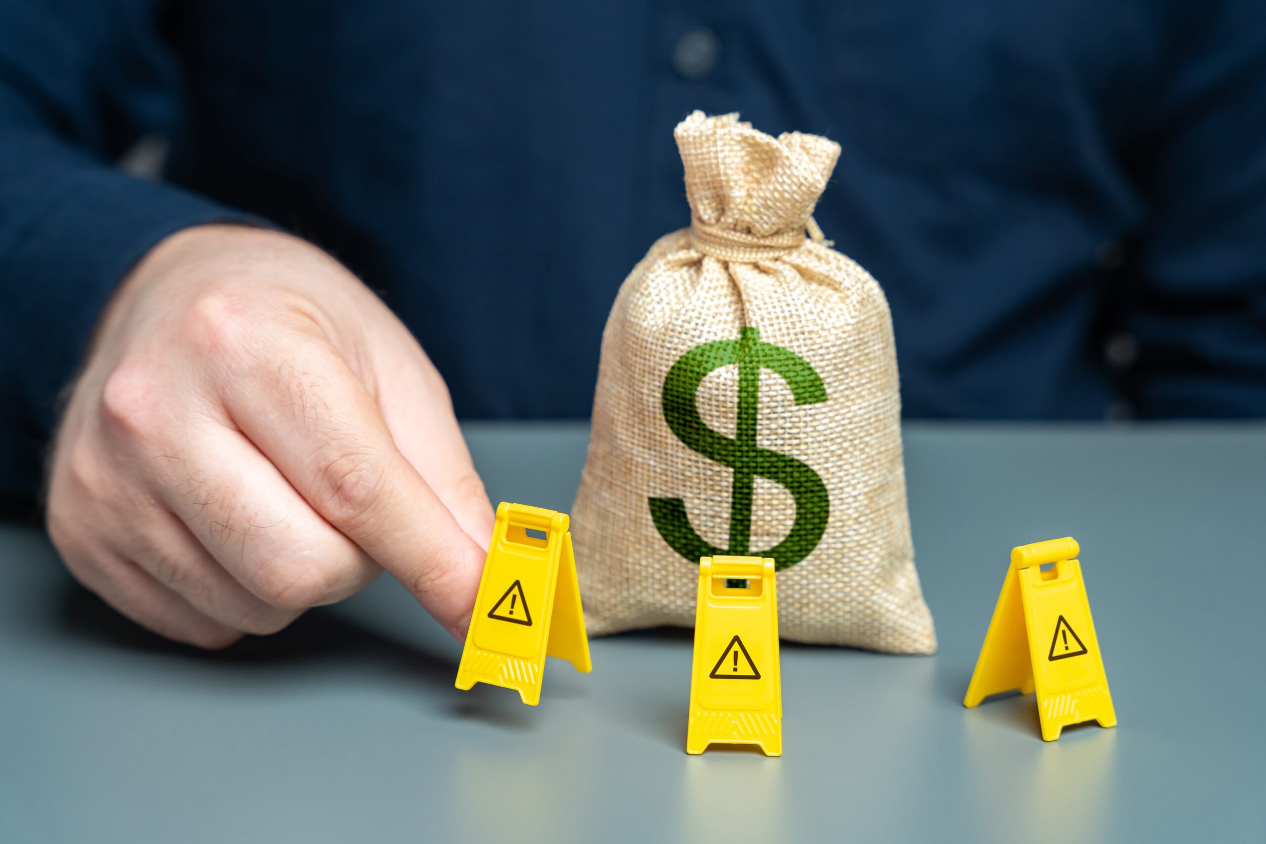 A man surrounds a dollar money bag with restrictive signs.
