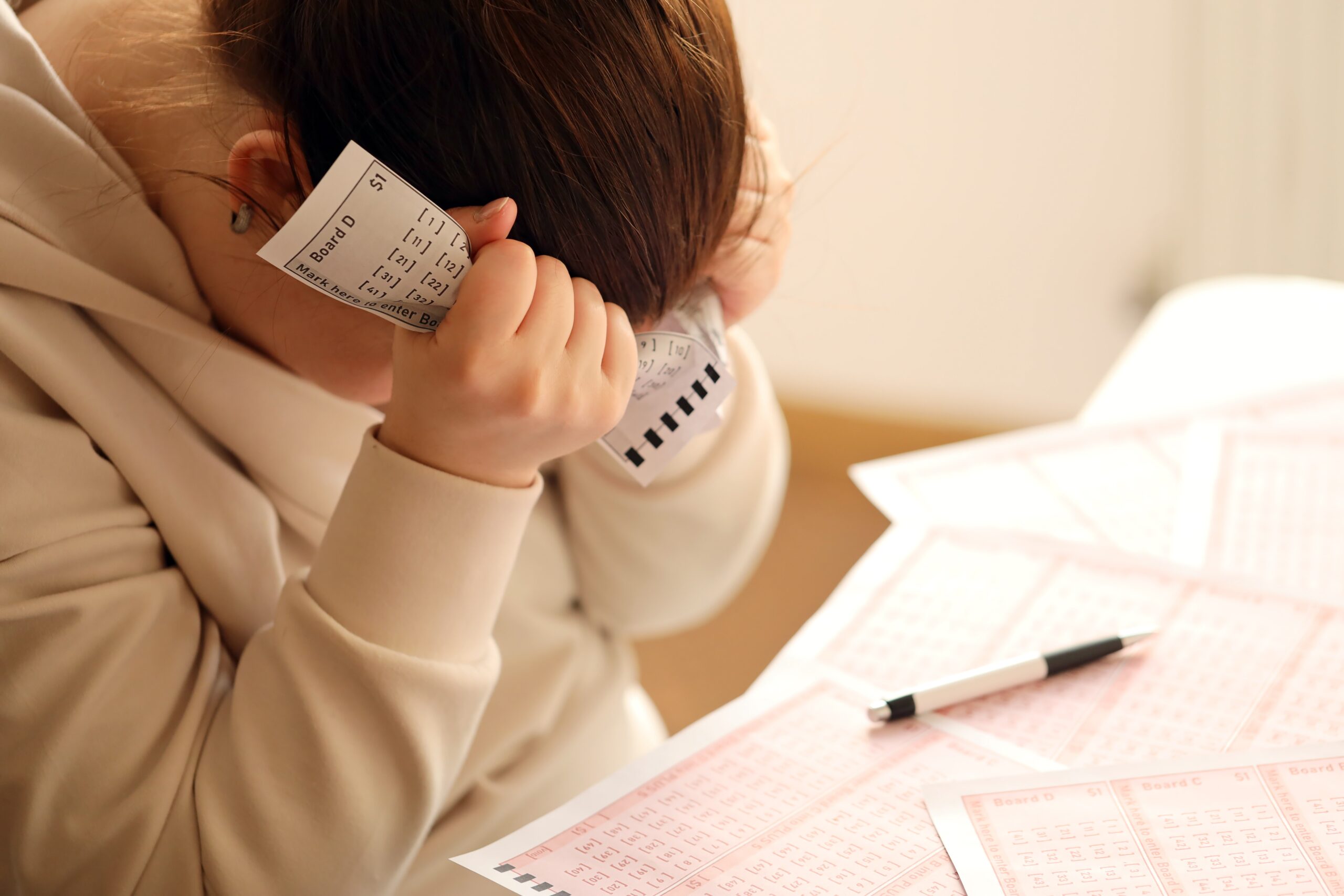 A sad young girl suffers from a loss after looking the unlucky result of the lottery gambling
