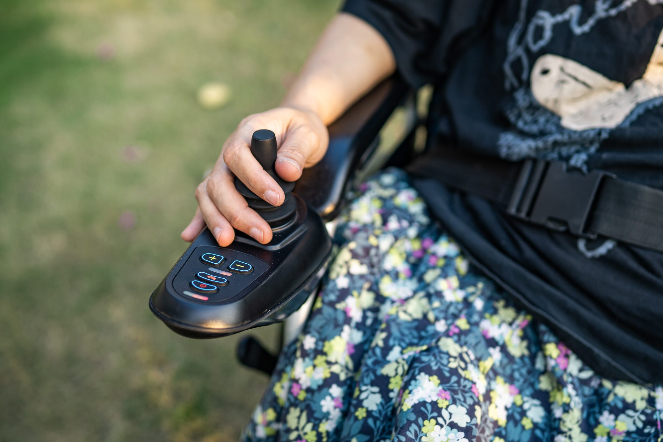 Asian lady woman patient on electric wheelchair with joystick and remote control