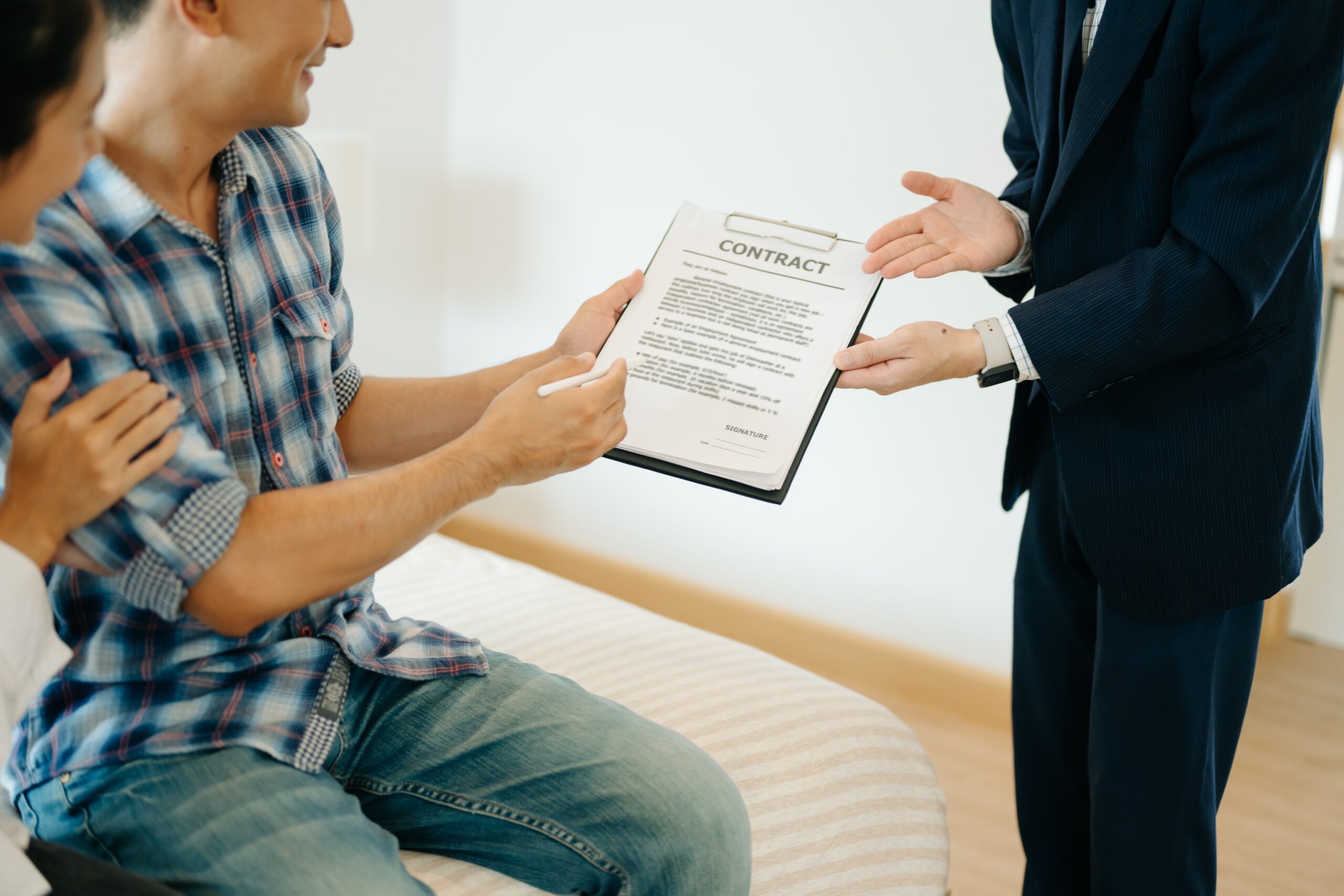 Asian man Real estate broker agent showing a house detail in her file to the young Asian couple