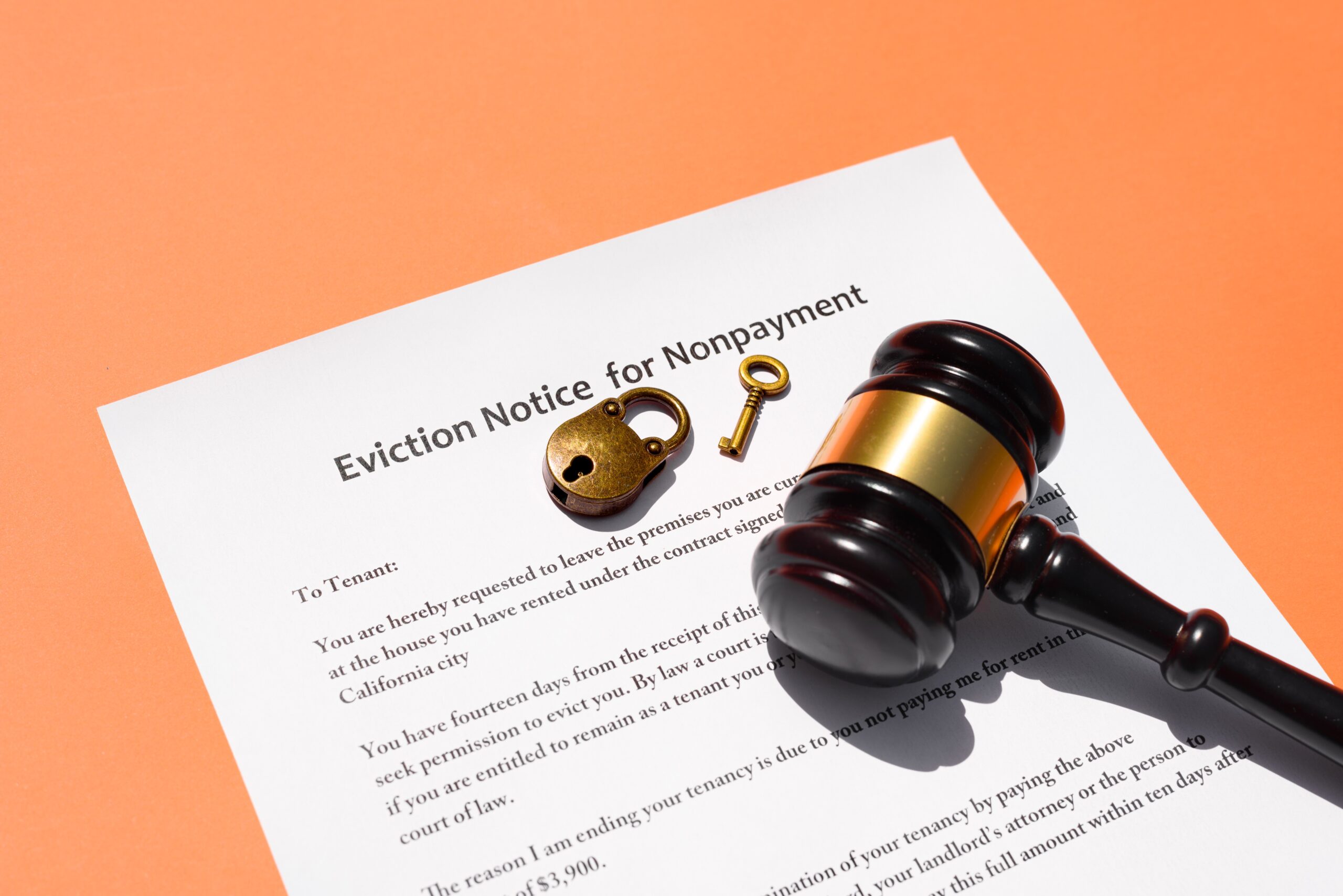 Eviction notice on a warm orange background and some house keys.