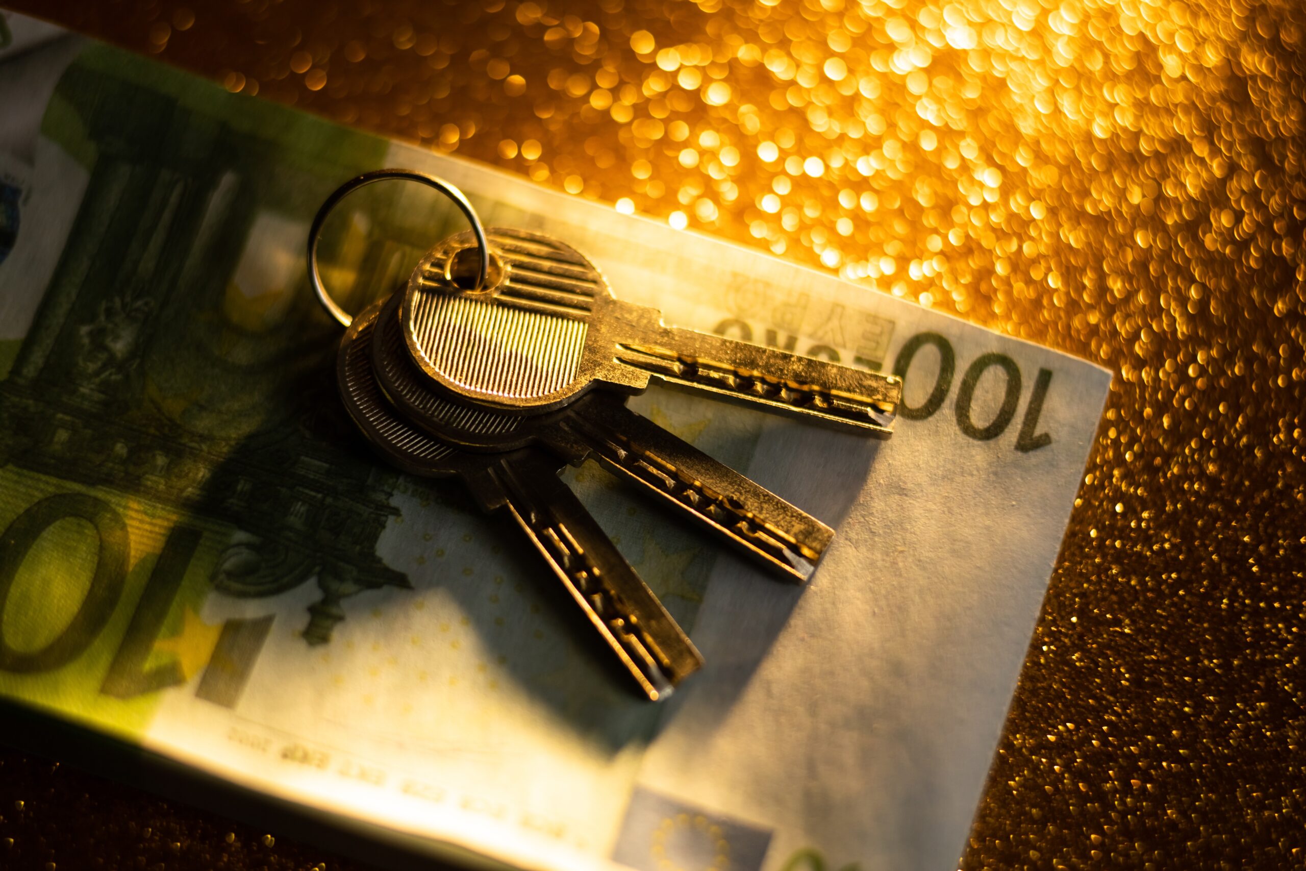 keys and money banknotes on golden background