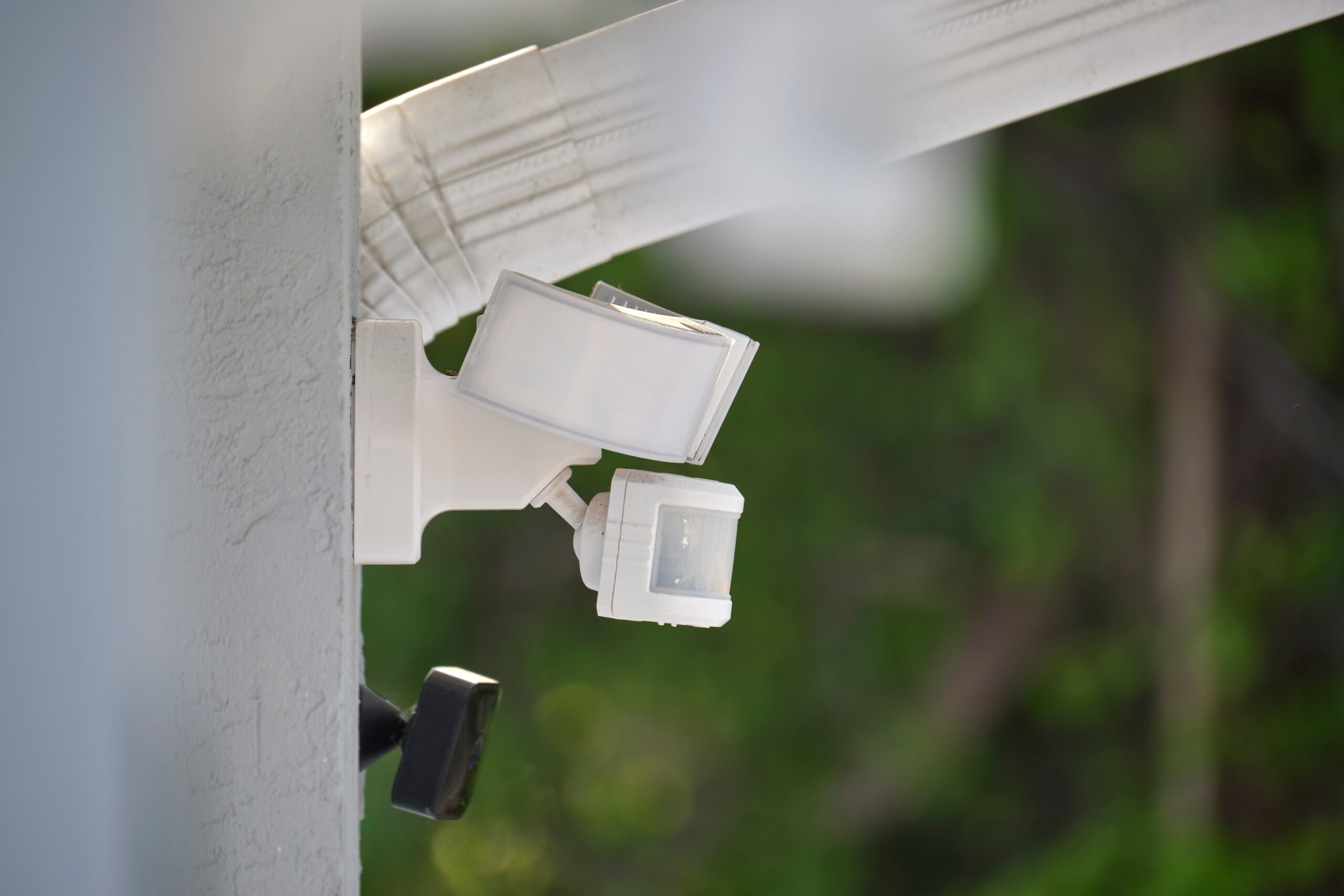 Motion sensor with light detector mounted on exterior wall