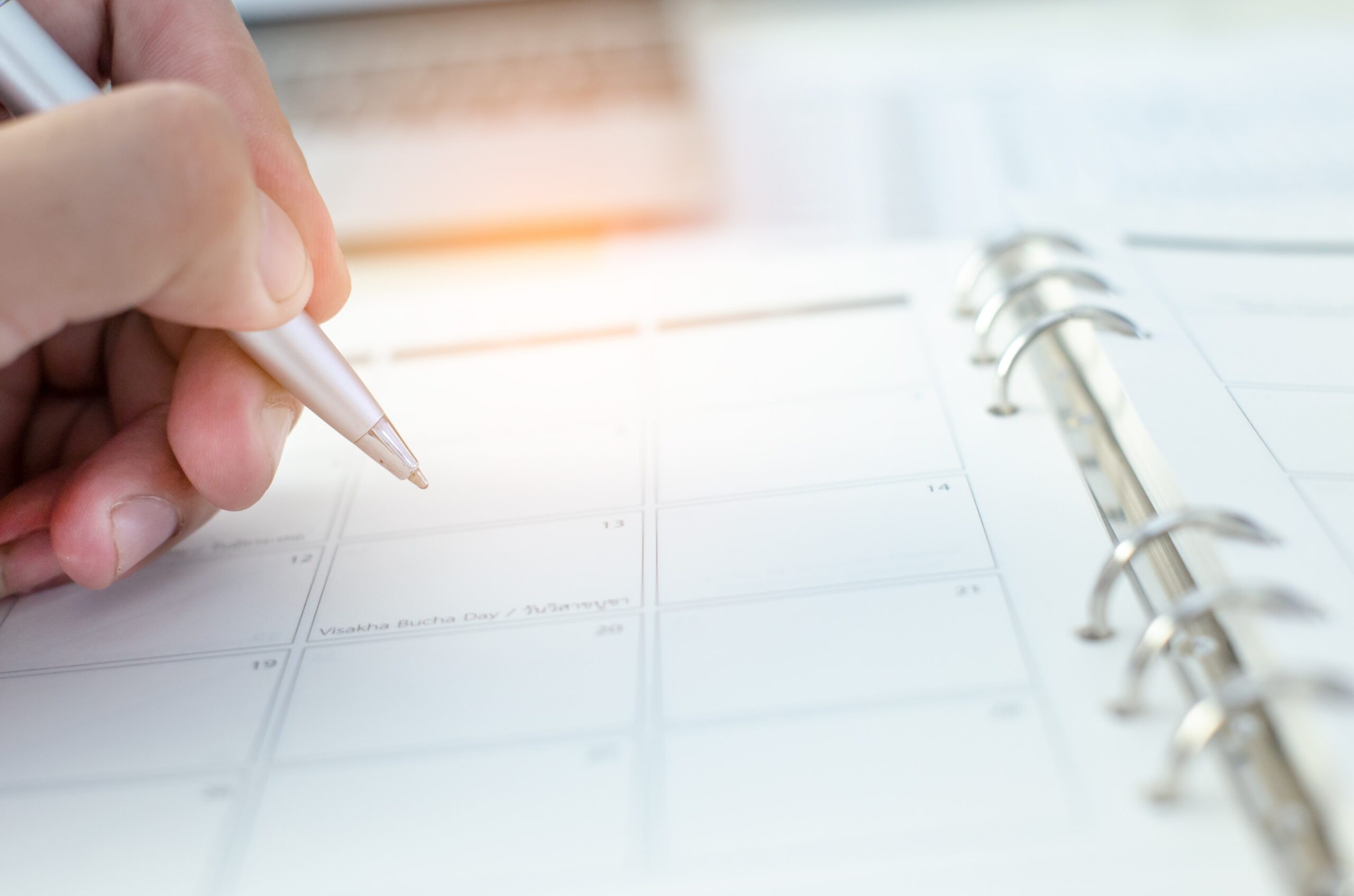 People hand holding pen closeup on open diary book closeup blur background