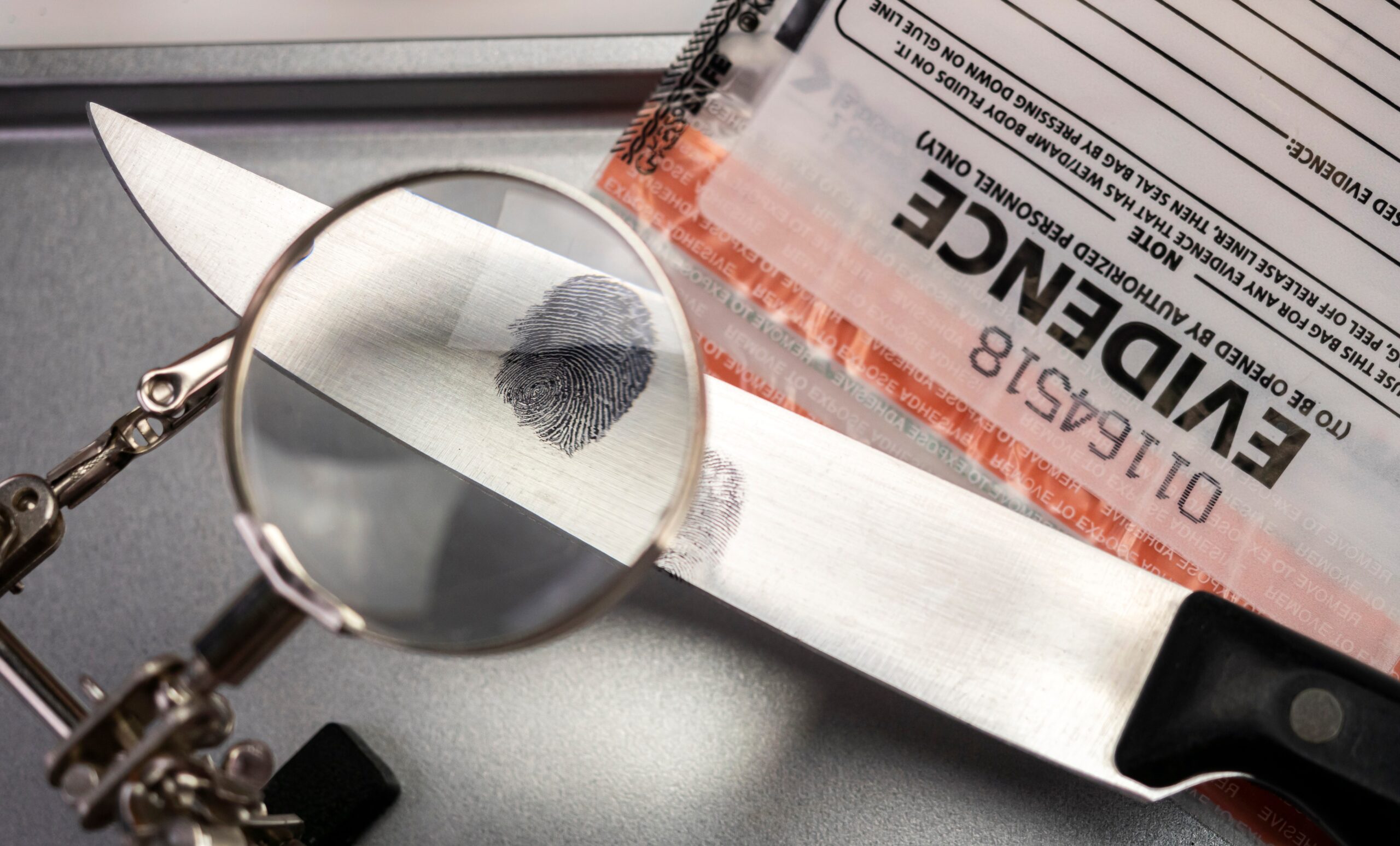 Police investigation of fingerprint on a knife, concept image