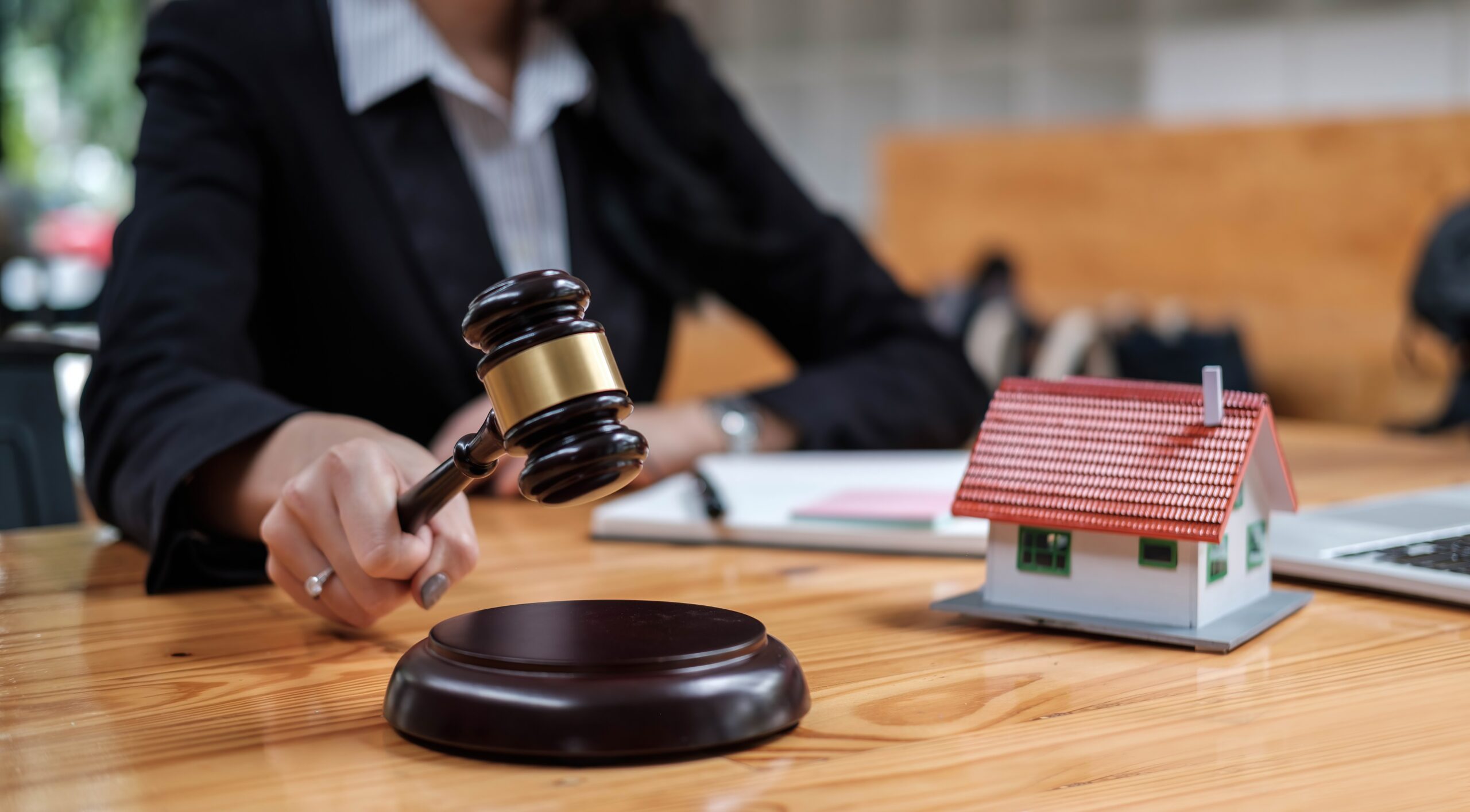 Real Estate Law concept. Gavel on sounding block in hand's female judge at a courtroom, working for