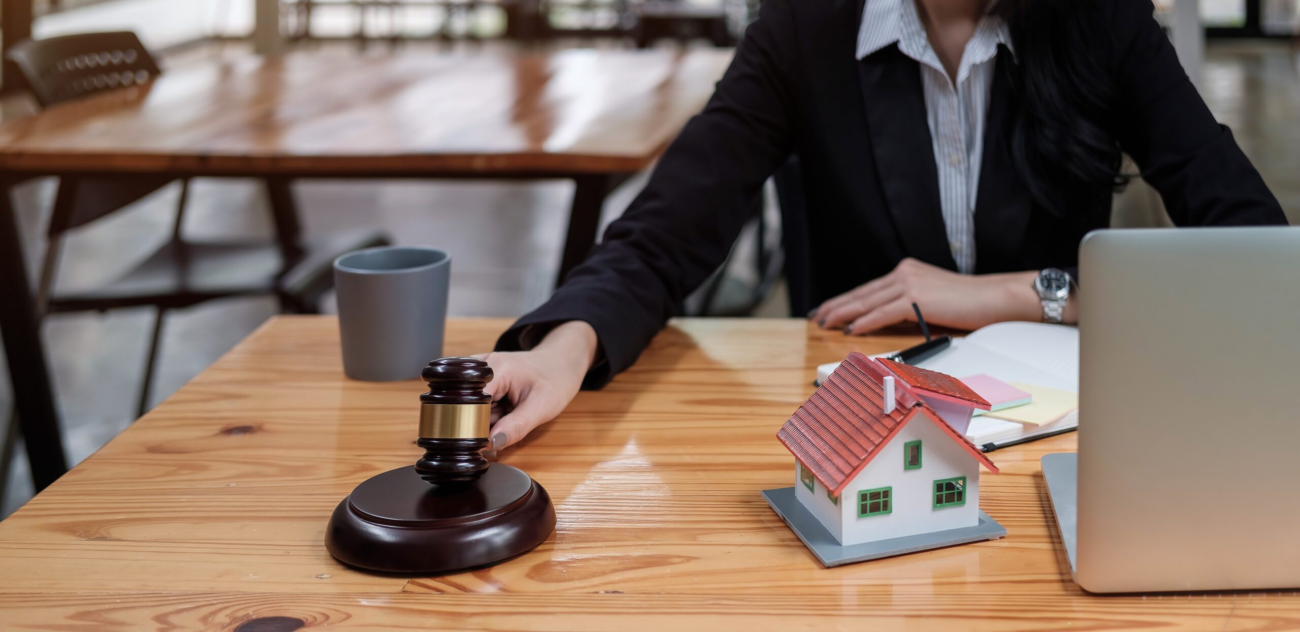 Real Estate Law concept. Gavel on sounding block in hand's female judge at a courtroom, working for
