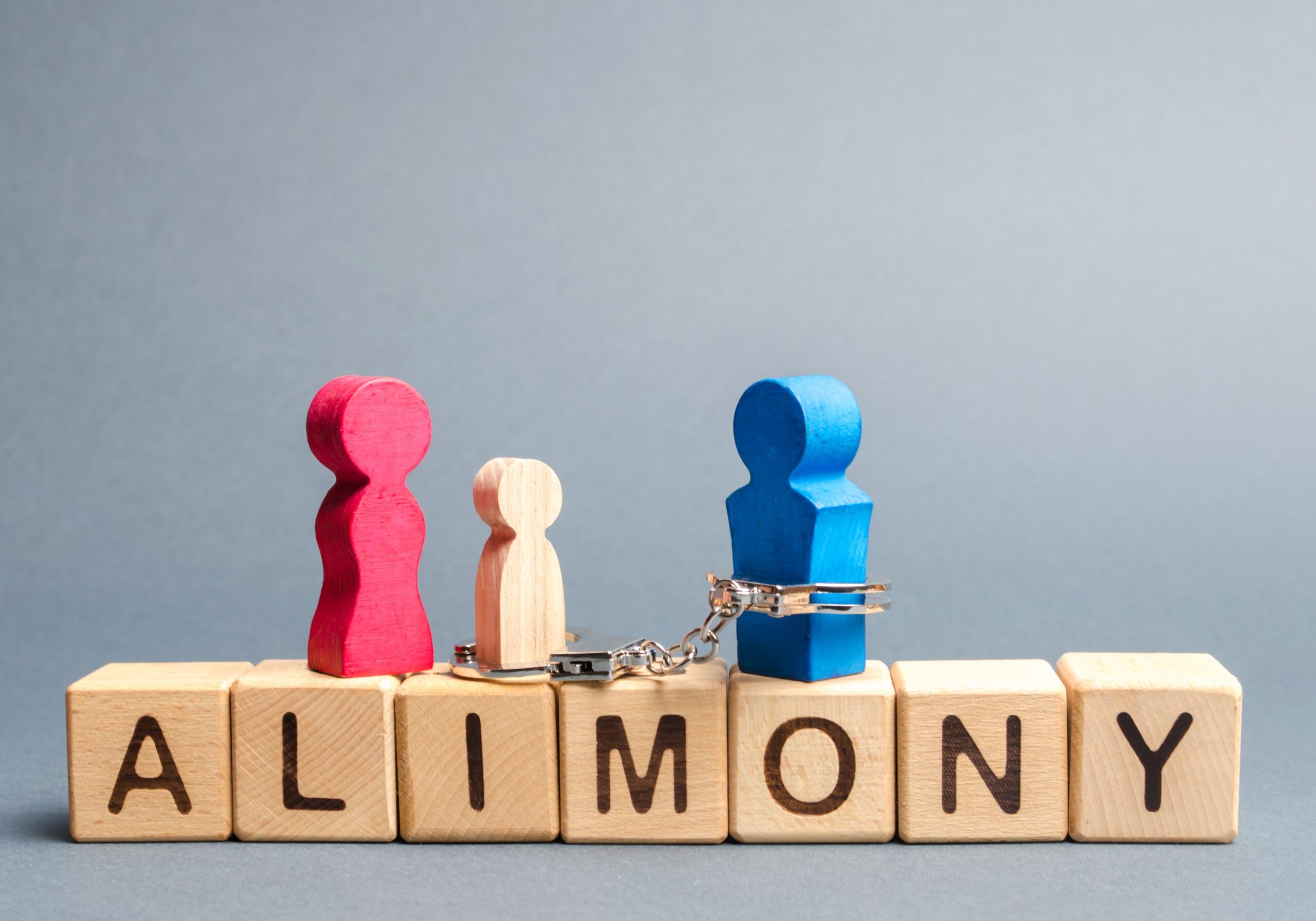 The figure of the man is handcuffed with the child of his ex-wife and is obliged to pay alimony